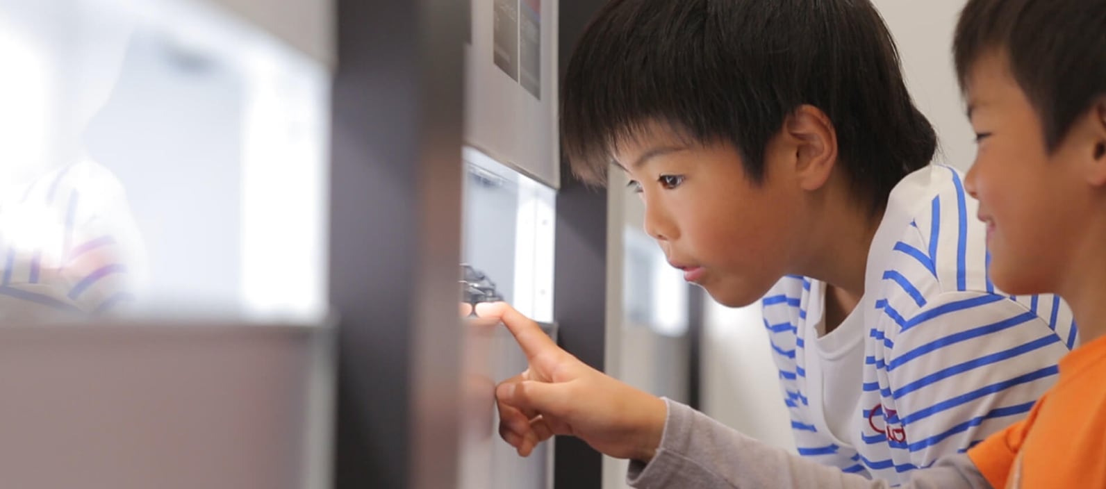 展示物を真剣に見つめる子供二人の写真